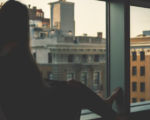 A person taking a relaxed break during a work session, looking out a window