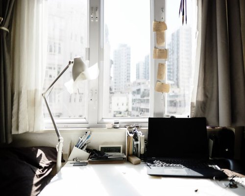 A workspace desk near a bright window illustrating the concept of a work pause
